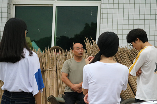 图为周师傅与实践团队成员“宇昌伞业”厂门外畅聊.JPG